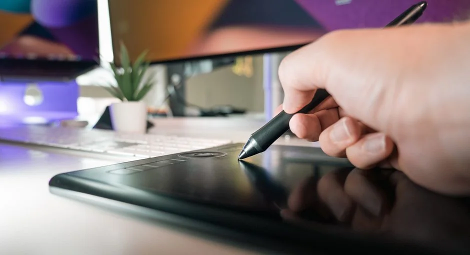 Two monitors on a desk display web design in a sleek modern office environment.